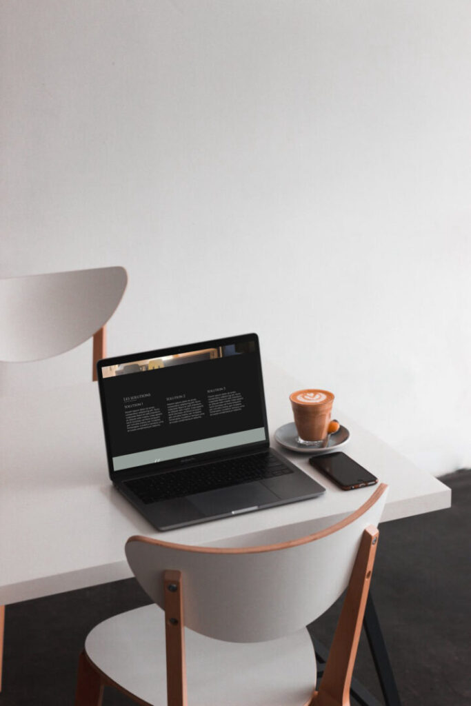 Un ordinateur portable sur une table avec une tasse de café.