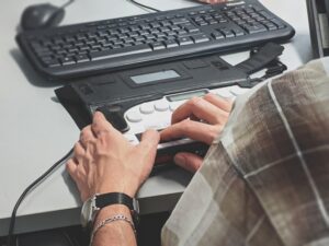 Une personne utilise un appareil d'assistance pour écrire.