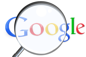 Loupe sur le logo Google symbolisant la recherche d'informations.