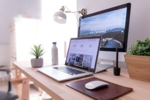 Bureau moderne avec ordinateur, plante et objets de travail.