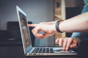 Deux personnes interagissent avec un ordinateur portable.